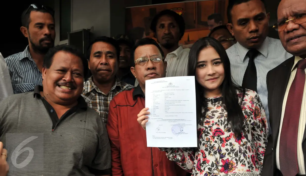 Pesinetron muda, Prilly Latuconsina menunjukkan surat bukti lapor di SPKT Polda Metro Jaya, Jakarta, Jumat (31/7/2015). Kedatangannya untuk melaporkan kasus foto bugil mirip dirinya yang beredar di dunia maya. (Liputan6.com/Panji Diksana)