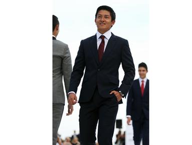 Rio Haryanto tampil modis dengan setelan jas hitam dan dasi merah diatas catwalk sebelum balapan di Monaco, (29/5/2016). (Bola.com/Twitter/Manor racing team)