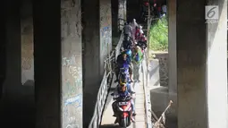 Pengendara motor melewati jembatan Ciliwung yang berada di bawah tol ruas Gadog, Ciawi, Bogor (16/68). Jembatan ini menjadi jalan alternatif bagi pemotor dari kawasan Bogor menuju arah Puncak dan Sukabumi. (Merdeka.com/Arie Basuki)