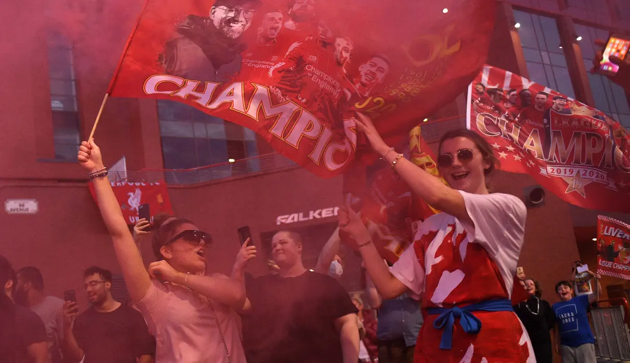 Para fans merayakan Liverpool memenangkan gelar juara Liga Primer Inggris setelah kemenangan Chelsea 2-1 atas Manchester City, di luar stadion Anfield di Liverpoo (25/6/2020). Pasukan Jurgen Klopp memastikan gelar liga ke-19 untuk klub dengan rekor tujuh pertandingan tersisa. (AFP Photo/Oli Scarff)
