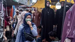 Pemerintah melalui Menteri Keuangan (Menkeu) Purbaya Yudhi Sadewa mengambil langkah tegas untuk menyetop impor pakaian bekas. Tampak dalam foto, pembeli berjalan di antara kios-kios penjual pakaian lokal di salah satu pasar tradisional, Jakarta, Kamis 20 November 2025. (BAY ISMOYO/AFP)