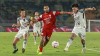 Striker asing Persis Solo, Jhon Cley, berusaha melepaskan diri dari kawalan dua bek Bali United, Ricky Fajrin (kiri) dan Kadel Arel (kanan) dalam duel lanjutan BRI Liga 1 di Stadion Manahan, Solo, Kamis (6/3/2025). (Bola.com/Radifa Arsa)