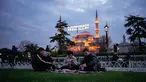 Orang-orang berbuka puasa selama bulan suci Ramadhan, di luar masjid Sultanahmet berlatar tulisan dalam bahasa Turki "Muhammad adalah utusan Allah", Istanbul, Turki, Rabu 25 Februari 2026. Sepanjang Ramadan, Masjid Sultanahmet di Istanbul, Turki, selalau ramai dikunjungi. (AP Photo/Emrah Gurel)