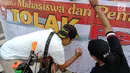 Masyarakat menandatangi spanduk petisi menolak gerakan people power saat car free day (CFD) di kawasan Thamrin, Jakarta, Minggu (19/5/2019). Aliansi Mahasiswa dan Pemuda Cinta NKRI mengajak masyarakat menandatangani petisi mendukung KPU dan Bawaslu pasca Pilpres 2019. (Liputan6.com/Faizal Fanani)