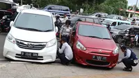 Petugas menderek dan menggembosi ban mobil yang parkir sembarangan di kawasan Tebet, Jakarta, Kamis (28/3). Meskipun berulang kali ditertibakan, namun masih banyak pengendara yang nekat parkir sembarangan sehingga mengganggu arus lalu lintas. (Liputan6.com/Immanuel Antonius)