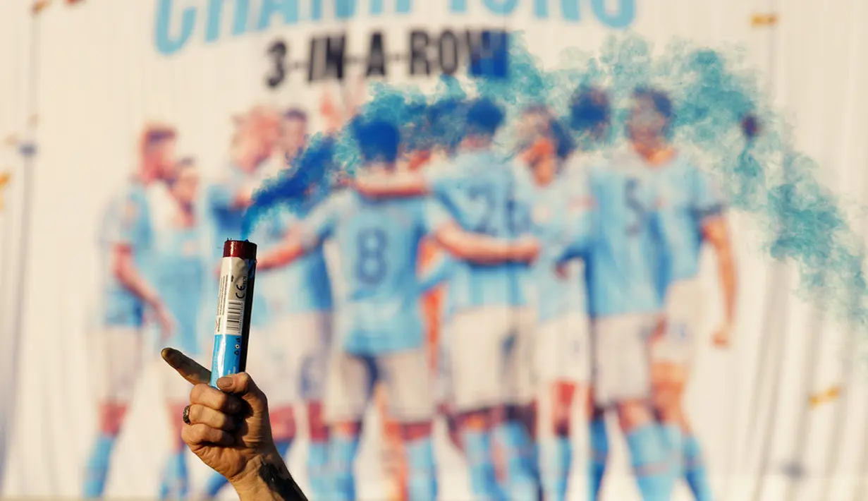 <p>Para suporter Manchester City yang mendatangi Etihad Stadium tak lupa mengenakan atribut seperti jersey, syal, dan bendera, sambil menyalakan suar. (AP Photo/Jon Super)</p>