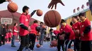 Pemain New Orleans Pelicans, Shawn Dawson mengajarkan para siswa bermain basket dalam acara amal di Sekolah Migran Huangzhuang, Beijing, Tiongkok (11/10). (AP Photo/Ng Han Guan)