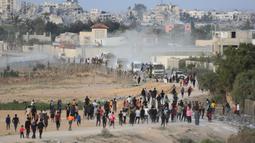 Warga Palestina membongkar paksa truk berisi bantuan kemanusiaan yang keluar dari Dermaga Trisula yang dibangun oleh Amerika Serikat. (Foto: AFP)