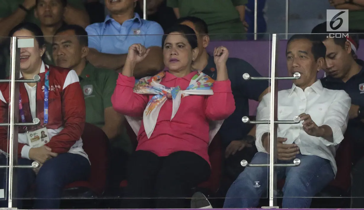 Ibu Negara, Iriana Joko Widodo (tengah) saat menyaksikan laga final bulutangkis beregu putra Asian Games 2018 antara Indonesia melawan China di Istora Kompleks GBK, Jakarta, Rabu (22/8). Indonesia kalah dari China 1-3. (Liputan6.com/Helmi Fithriansyah)