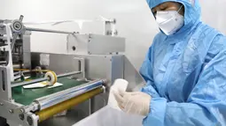 Seorang pekerja menyortir masker kesehatan N95 yang tidak memenuhi standar di perusahaan produsen masker di Shenyang, China, 8 Februari 2020. Nantinya masker N95 tersebut akan dipasok ke garis depan upaya pencegahan wabah virus corona di provinsi Hubei dan Liaoning. (Xinhua/Yao Jianfeng)