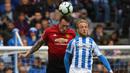 Bek Manchester United, Phil Jones, duel udara dengan pemain Huddersfield Town, Alex Pritchard, pada laga Premier League di Stadion John Smith, Minggu (5/5). Kedua tim bermain imbang 1-1. (AFP/Paul Ellis)