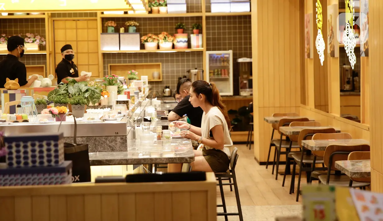 Pengunjung menyantap makanan di restoran yang berada di Mal Central Park, Jakarta, Jumat (20/8/2021). Restoran dalam pusat perbelanjaan kini bisa makan di tempat dengan syarat kapasitas maksimal 25 persen, satu meja maksimal dua orang, dan waktu makan maksimal 30 menit. (Liputan6.com/Angga Yuniar)