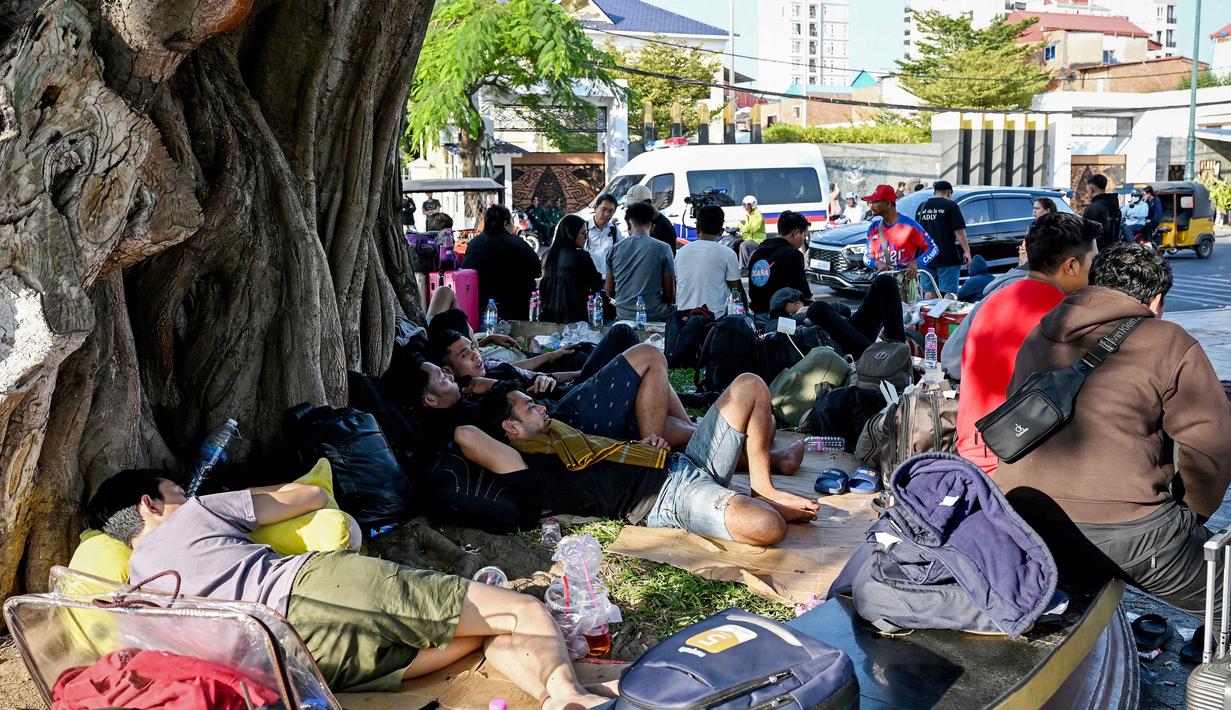 Pihak KBRI di Phnom Penh menyatakan permasalahan utama dari para WNI adalah tidak memegang paspor dan menetap di Kamboja tanpa perizinan keimigrasian yang valid. Tampak dalam foto, orang-orang berkumpul di depan Kedutaan Besar Republik Indonesia (KBRI) di Phnom Penh, Kamboja, pada Rabu 21 Januari 2026. (TANG CHHIN Sothy/AFP)