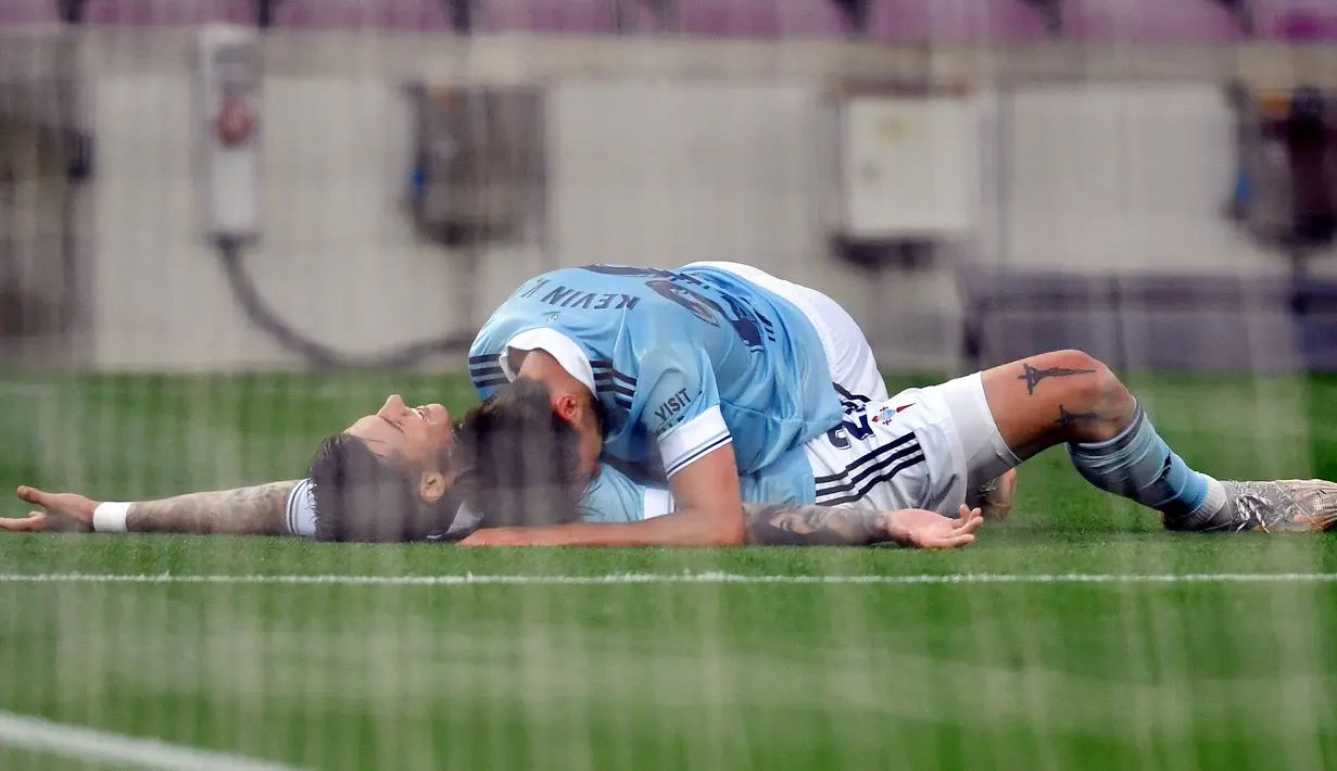 Pemain Celta Vigo, Santi Mina, melakukan selebrasi usai mencetak gol ke gawang Barcelona pada laga Liga Spanyol di Stadion Camp Nou, Minggu (16/5/2021). Barca takluk dengan skor 1-2. (AFP/Pau Barrena)
