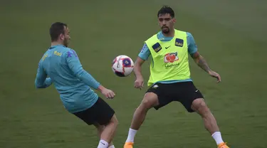 Pemain Brasil Arthur (kiri) dan Lucas Paqueta mengambil bagian dalam sesi latihan di Granja Comary, Rio de Janeiro, Minggu (27/3/2022). Brasil akan menghadapi Bolivia dalam laga lanjutan Kualifikasi Piala Dunia 2022 zona Amerika Selatan pada Rabu, 30 Maret 2022 mendatang. (MAURO PIMENTEL/AFP)