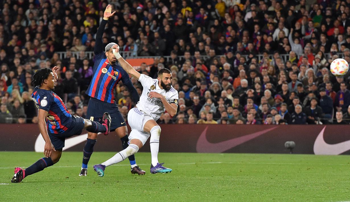 Striker Real Madrid, Karim Benzema melepaskan tendangan yang menghasilkan gol keempat timnya ke gawang Barcelona pada laga leg kedua semifinal Copa del Rey 2022/2023 di Camp Nou Stadium, Barcelona, Kamis (6/4/2023) dini hari WIB. (AFP/Pau Barrena)