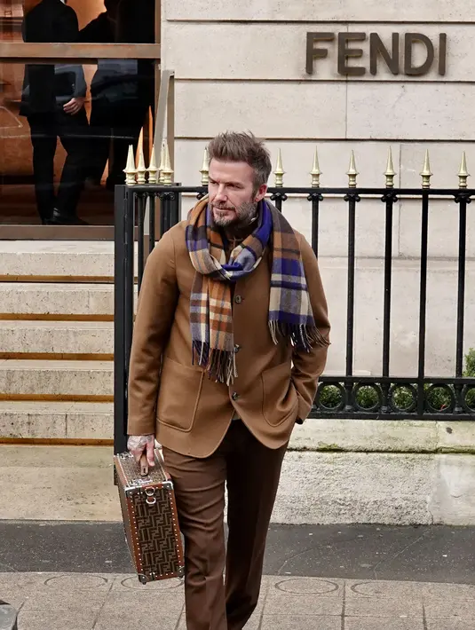 Seperti saat dia berkunjung di gerai Fendi. Ia mengenakan blazer cokelat sambil menjinjing koper Fendi berwarna cokelat dengan motif FF Jacquard. [instagram/davidbeckham]