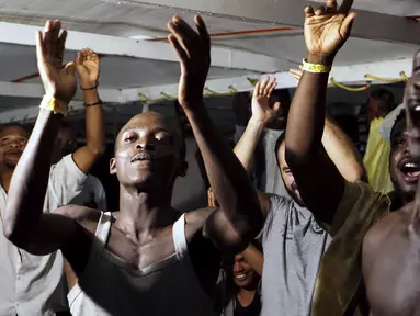 Para imigran di atas kapal Open Arms merayakan berita tentang seorang jaksa penuntut Italia yang telah memerintahkan bahwa para migran akan turun di pulau Lampedusa, Italia selatan (20/8/2019). Setidaknya 15 migran lainnya melompat ke laut dari kapal Open Arms untuk menuju pantai Italia. (AP Photo/F