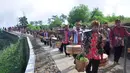 Warga membawa tenongan menuju makam sesepuh mereka saat mengikuti Sadranan Rejeban Plabengan di Lereng Gunung Sumbing, Temanggung, Jawa Tengah, Jumat (22/3). Dalam tradisi ini warga menggelar doa dan makan bersama di makam sesepuh. (Liputan6.com/Gholib)