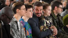 David Beckham bersama anak-anaknya Romeo Beckham, Cruz Beckham dan Harper saat menghadiri peragaan busana Musim Gugur/Musim Dingin 2020 Victoria Beckham dalam acara London Fashion Week di London, (16/2/2020). Beckham tampil dengan setelan jas hitam. (AFP/Daniel Leal-Olivas)