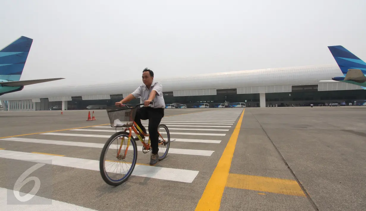 Petugas bersepeda di dekat hanggar terbesar di dunia milik PT Garuda Maintenance Facility di area Bandara Soekarno-Hatta, Tangerang, Senin (28/9). Pembangunan hanggar ini menelan biaya puluhan juta dolar AS.(Liputan6.com/Angga Yuniar)