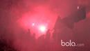 Aremania menyalakan flare usai timnya menang 1-0 atas Sriwijaya FC pada babak delapan besar Piala Presiden 2017 di Stadion Manahan, Solo. Jumat (26/2/2017). (Bola.com/Nicklas Hanoatubun)