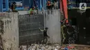 Pekerja kebersihan mengangkat sampah yang menumpuk di pintu air Manggarai, Jakarta, Selasa (22/9/2020). Tingginya curah hujan membuat kiriman sampah menumpuk di pintu air Manggarai. (Liputan6.com/Faizal Fanani)