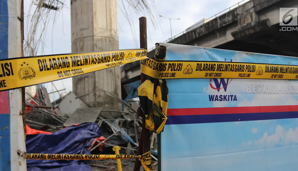 Garis polisi terpasang di lokasi ambruknya tiang girder proyek Tol Becakayu di dekat Gerbang Tol Kebon Nanas, Jakarta Timur, Selasa (20/2). Dugaan sementara tiang itu ambruk lantaran bracket tidak kuat menyangga. (Liputan6.com/Arya Manggala)