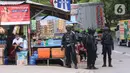 Personel Brimob bersenjata melakukan penjagaan ketat di depan pintu masuk Tol Bitung, Tangerang, Baten, Selasa (6/10/2020). Penjagan ketat dilakukan untuk mengamankan dan mencegah aksi buruh yang akan menggelar aksi menolak UU Cipta Kerja. (Liputan6.com/Angga Yuniar)