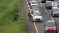 Pedagang menawarkan daganganya ke para pemudik di Jalan tol Cikopo - Palimanan KM 73, Purwakarta, Jawa Barat, Sabtu (30/4/2022). Padatnya arus lalu lintas ruas tol trans jawa, membuat pedagang asongan turun ke jalan. (Liputan6.com/Herman Zakharia)