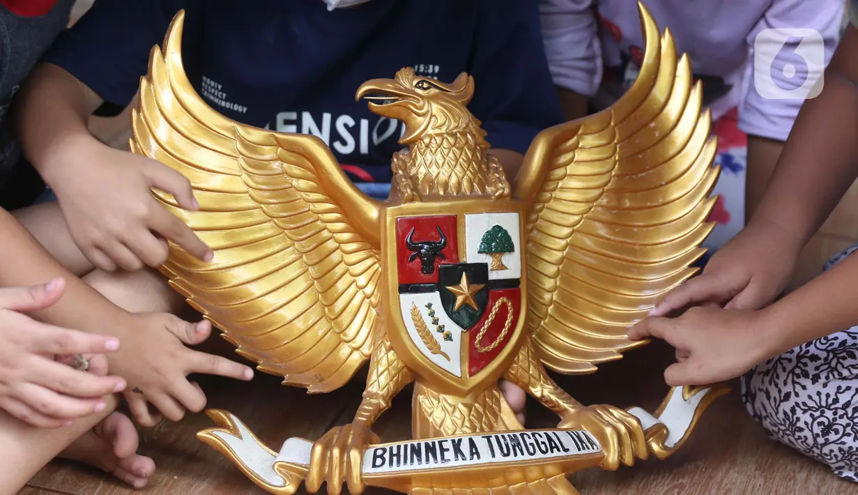 <p>Anak-anak melihat lambang burung Garuda Pancasila di Kampung Pancasila, Karang Tengah, Kota Tangerang, Selasa (1/6/2021). Kegiatan tersebut antara lain seperti gotong royong membersihkan kampung dan sosialisasi penanaman nilai Pancasila kepada warga . (Liputan6.com/Angga Yuniar)</p>