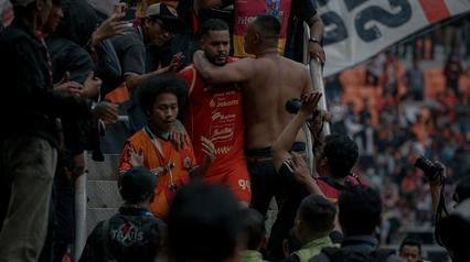 Pemain Persija Jakarta, Emaxwell Souza merayakan golnya dengan penonton yang hadir pada laga pekan terakhir BRI Super League 2025/2026 pada Sabtu (23/5) sore WIB. (Bola.com/Abdul Aziz)