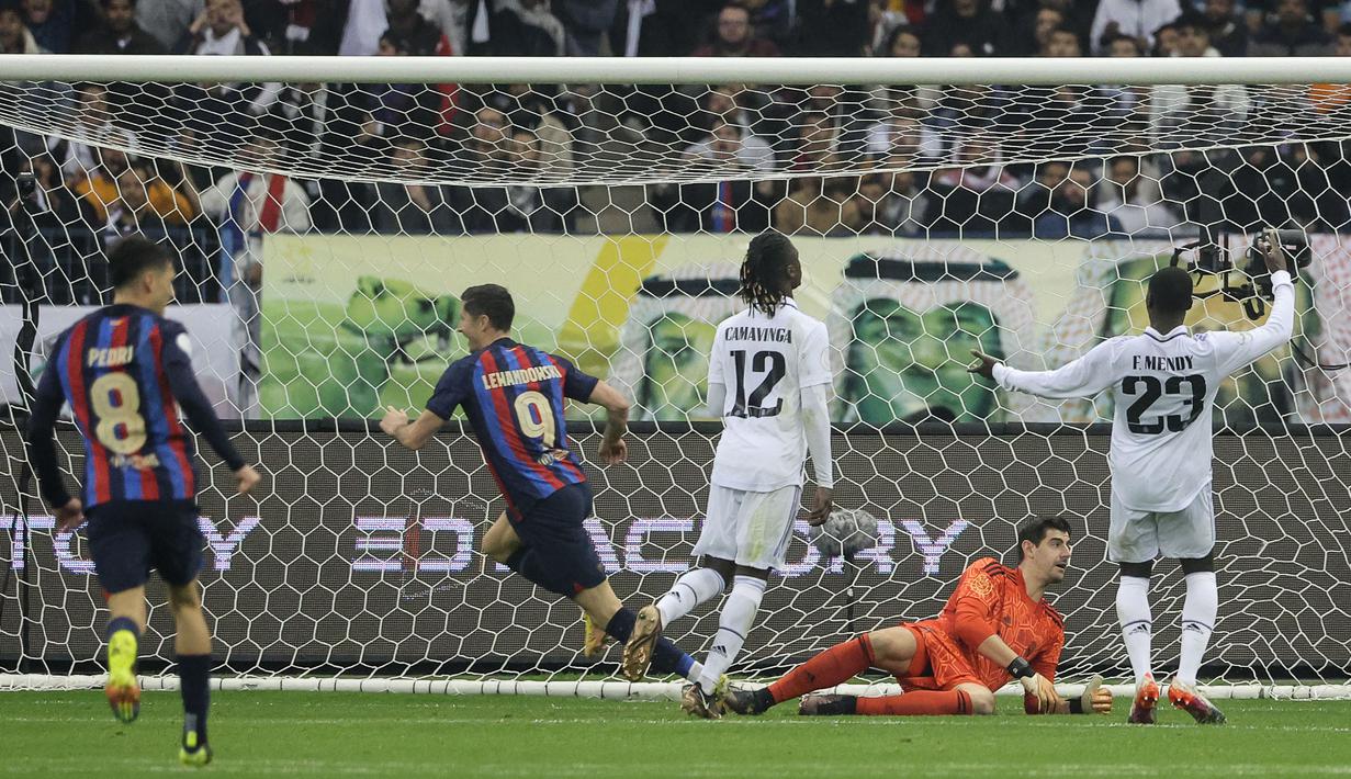 Robert Lewandowski (dua kiri) berhasil menggandakan keunggulan untuk Barcelona dalam pertandingan Supercopa de Espana melawan Real Madrid di King Fahd Stadium, Arab Saudi, Senin (16/1/2023) WIB. (AFP/Guiseppe Cacace)