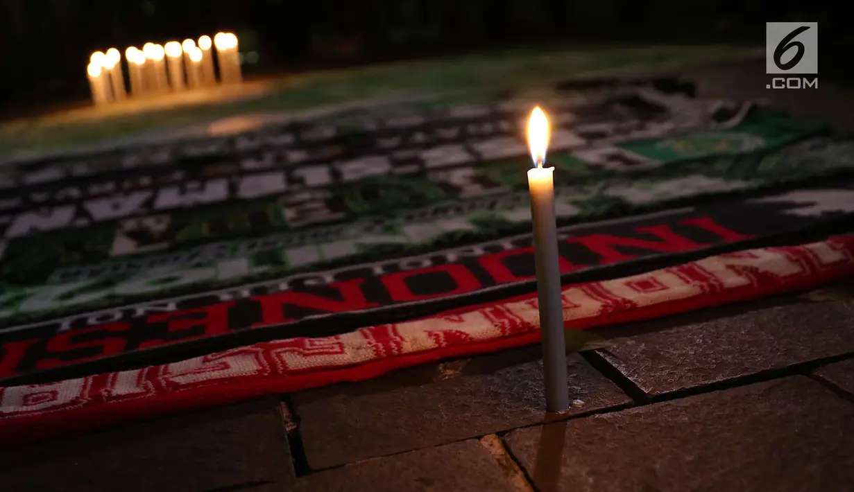 Syal gabungan suporter klub sepak bola dalam aksi lilin terkait solidaritas tragedi teror bom di Surabaya dan Sidoarjo di Taman Suropati, Jakarta, Senin (14/5). (Liputan6.com/Immanuel Antonius)