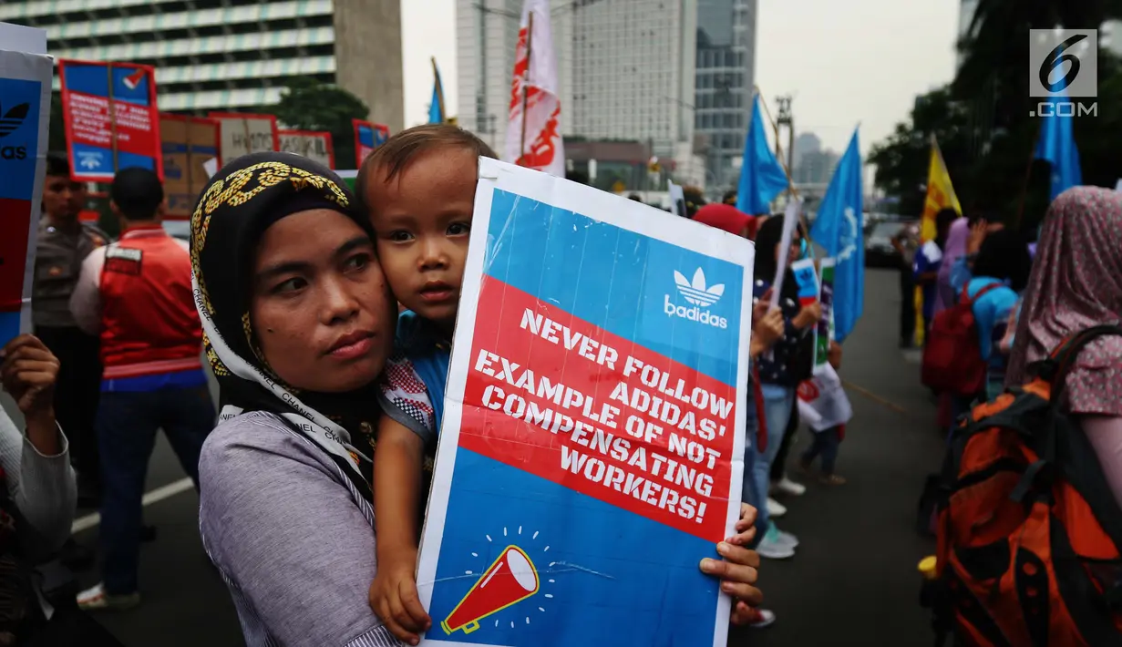 Seorang buruh membawa anak saat melakukan aksi di depan Kedutaan besar Jerman di Jakarta, Selasa (18/7). Mereka menuntut PT Panarub Dwikarya karena dinilai telah berlaku tidak adil pada buruh yang bekerja di perusahan tersebut. (Liputan6.com/Angga Yuniar)