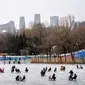 Orang-orang menggunakan kursi yang dimodifikasi untuk meluncur melintasi es dalam kolam saat pekan liburan Tahun Baru Imlek di taman umum selama pekan liburan Tahun Baru Imlek di Beijing, China, Kamis (26/1/2023). (AP Photo/Mark Schiefelbein)