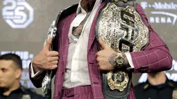 Petarung MMA Conor McGregor berpose dengan memperlihatkan dua sabuk miliknya jelang konferensi pers di New York, AS (20/9). McGregor akan melawan Khabib Nurmagomedov di UFC setelah absen selama dua tahun. (AP Photo/Seth Wenig)