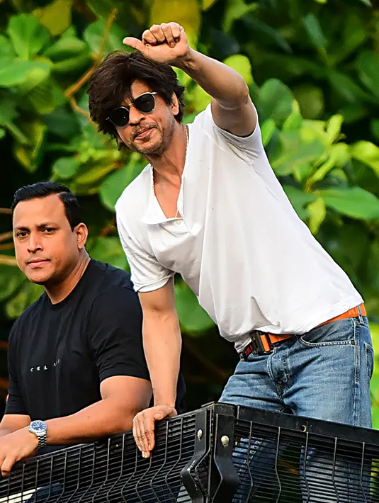 Shah Rukh Khan memberikan isyarat kepada penggemar pada perayaan ulang tahunnya ke-54 dari balkon rumah King of Bollywood itu di Mumbai, Sabtu (2/11/2019). Melalui balkon rumahnya, Shah Rukh Khan menyapa dan menyampaikan rasa terima kasihnya kepada penggemarnya yang sudah hadir. (Sujit Jaiswal/AFP)