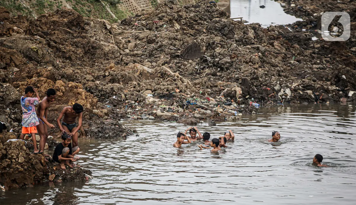Anak-anak bermain di Sungai Ciliwung yang surut di kawasan Bukit Duri, Jakarta, Sabtu (8/8/2020). Penyusutan debit air Sungai Ciliwung tersebut karena memasuki masa kemarau 2020 yang menurut BMKG akan mencapai puncaknya pada Agustus. (Liputan6.com/Faizal Fanani)