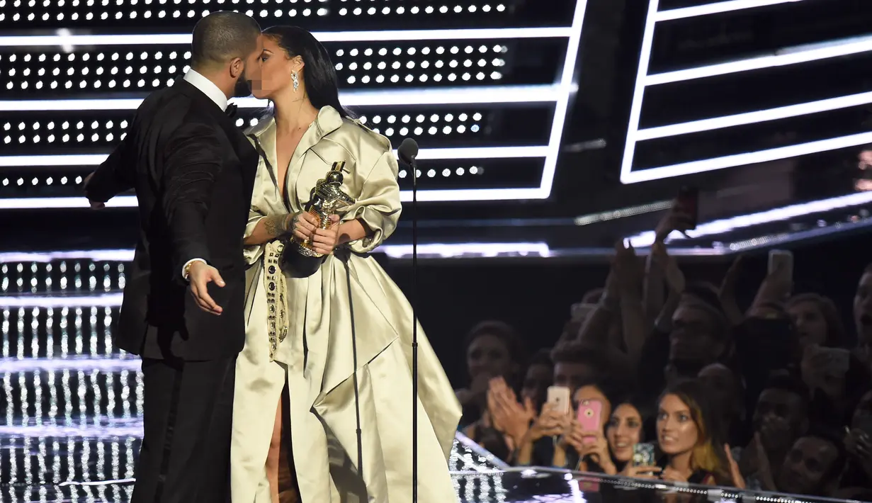 Rapper Drake mencium Rihanna usai memberikan penghargaan Michael Jackson Video Vanguard Award di ajang MTV VMA 2016, New York, AS, (28/8). Menurut sebuah sumber, keduanya memang saling mencintai satu sama lain. (AFP PHOTO/Michael Loccisano)