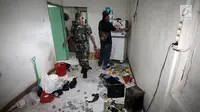 Petugas menyisir sebuah rumah lokasi penggerebekan peredaran narkoba di Kampung Ambon, Jakarta, Rabu (24/1). Penggerebekan dilakukan untuk mengamankan penyalahgunaan narkotika yang kerap dilakukan di Kampung Ambon. (Liputan6.com/Arya Manggala)