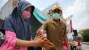 Peserta menggunakan cairan hand sanitizer saat lomba menangkap belut dengan menerapkan protokol Kesehatan di kawasan Pondok Cabe IV, Tangerang Selatan, Senin (17/8/2020). Lomba tersebut digelar untuk menyemarakkan HUT ke-75 Kemerdekaan Republik Indonesia. (merdeka.com/Faizal Fanani)