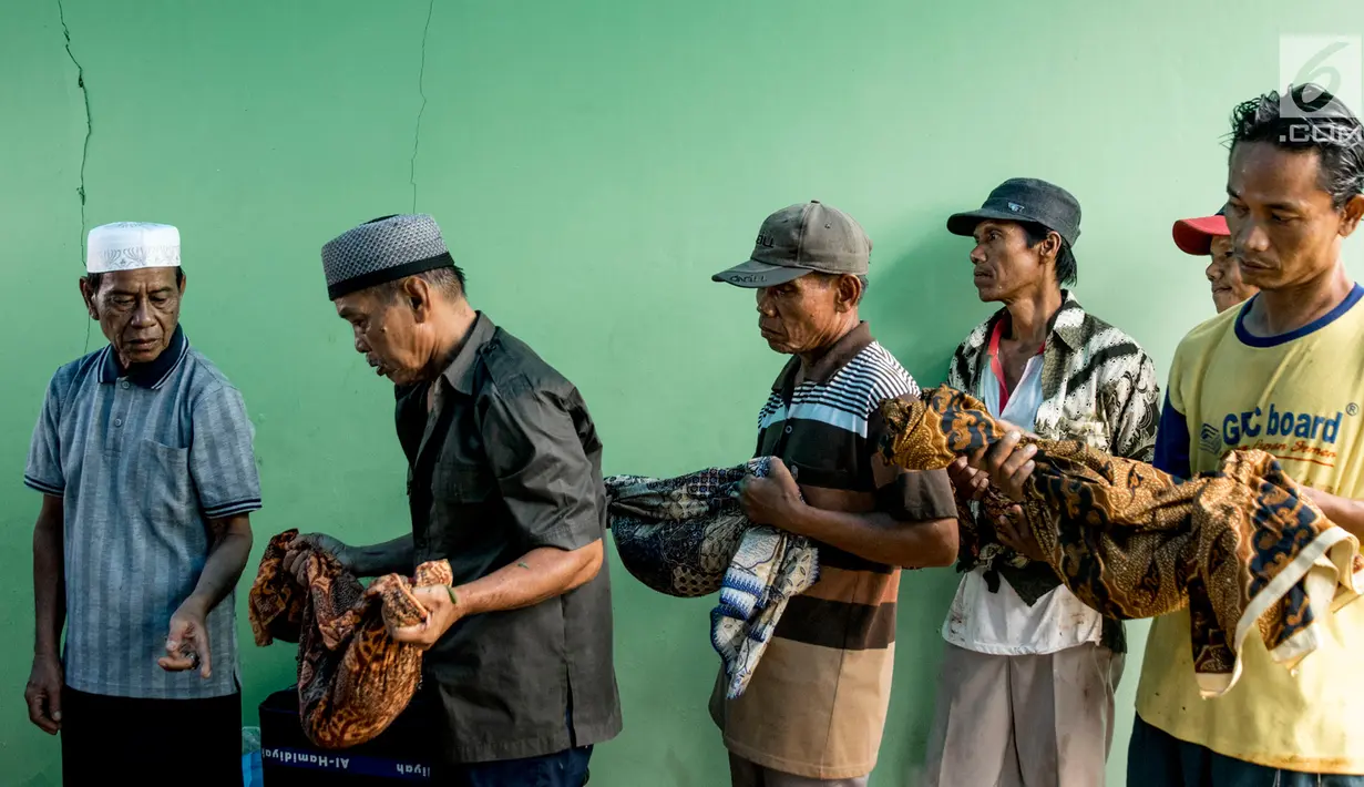 Panitia bersama keluarga pemilik makam memindahkan jenazah di TPU Grogol, Depok, Jawa Barat, (20/9). 525 makam di TPU tersebut dibongkar dan dipindahkan ke lokasi baru karena dilewati rencana pembangunan jalan tol Desari. (Liputan6.com/Immanuel Antonius)