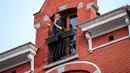Seorang wanita bertepuk tangan dari jendela untuk menunjukkan penghormatan terhadap orang-orang yang bertugas di garis depan melawan pandemi virus corona COVID-19 di Brussel, Belgia,Selasa (14/4/2020). Kasus COVID-19 di Belgia sebanyak 31.119 positif dan 4.157 meninggal. (Xinhua/Zhang Cheng)