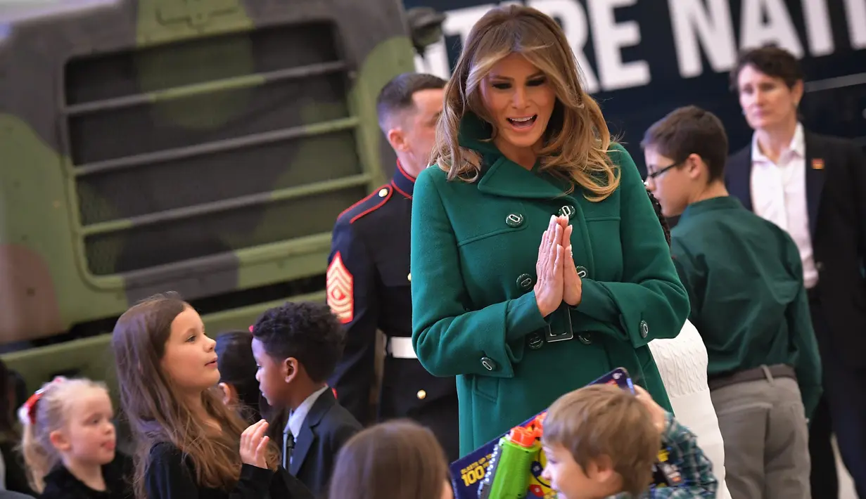 Melania Trump berinteraksi dengan anak-anak saat menghadiri Kampanye Program Korps Marinir AS "Toys For Tots" di Joint Base Anacostia-Bolling, Washington (13/12). Acara ini telah digelar lebih dari 70 tahun di AS. (AFP Photo/mandel Ngan)