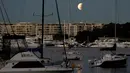 Fenomena gerhana bulan sebagian (parsial) terlihat di atas pelabuhan Sydney, Australia pada Rabu (17/7/2019) dini hari. Gerhana bulan parsial ini bisa diamati dari Amerika Selatan, Eropa, Afrika, Asia dan Australia. (AP Photo/Rick Rycroft)