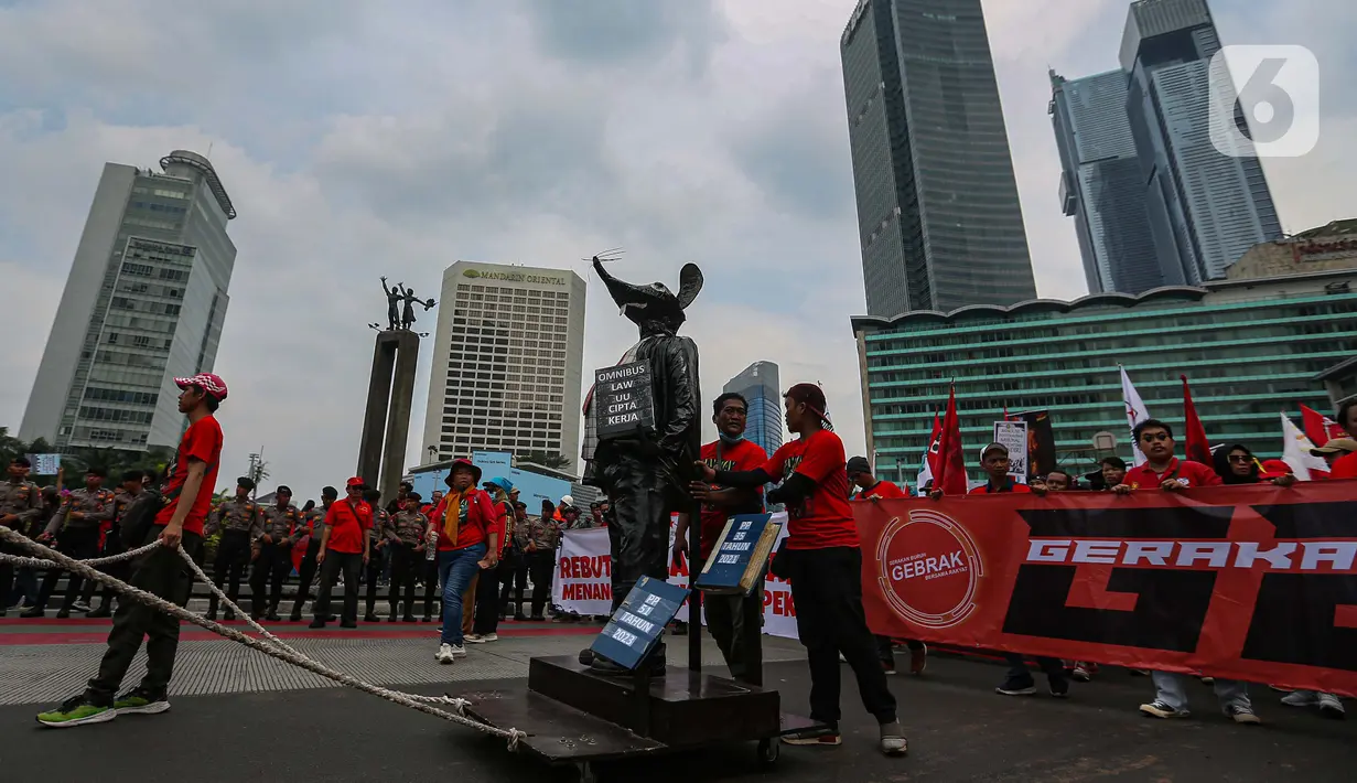 Buruh membawa patung tikus dalam aksi peringatan Hari Buruh atau May Day di kawasan Bundaran HI, Jakarta, Rabu (1/5/2024). (Liputan6.com/Angga Yuniar)