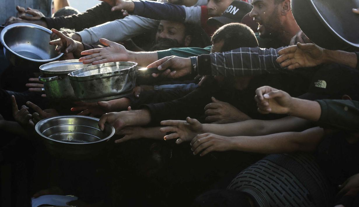 Otoritas Israel mengatakan, pintu masuk tersebut tidak dapat dioperasikan dengan aman dan belum mengatakan berapa lama akses penyeberangan tersebut akan ditutup. Tampak dalam foto, warga Palestina yang mengungsi berebut untuk makanan di Khan Younis, selatan Jalur Gaza pada Jumat 6 Maret 2026. (Bashar Taleb/AFP)