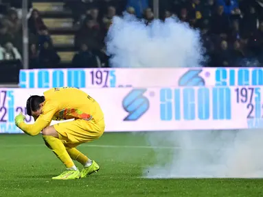 Kiper US Cremonese, Emil Audero bereaksi saat suar meledak di lapangan selama pertandingan pekan ke-23 Serie A Italia melawan Inter Milan di Stadion Giovanni Zini, Cremona, Italia utara, Minggu 1 Februari 2026 waktu setempat atau Senin (2/2/2026) dini hari WIB. (Piero CRUCIATTI/AFP)