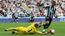Penjaga gawang Arsenal, Aaron Ramsdale (kiri), berhasil menghalau bola serangan dari pemain Newcastle United, Callum Wilson, dalam laga pekan ke-35 Premier League 2022/2023 yang berlangsung di St James Park, Minggu (7/5/2023). (AFP/Lindsey Parnaby)
